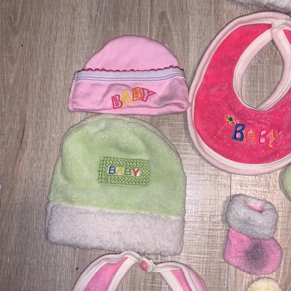 Colorful bundle of plush baby bibs, hats, and mittens